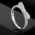 Silver bow-shaped ring with rhinestone and zircon crystal detailing on electroplated metal
