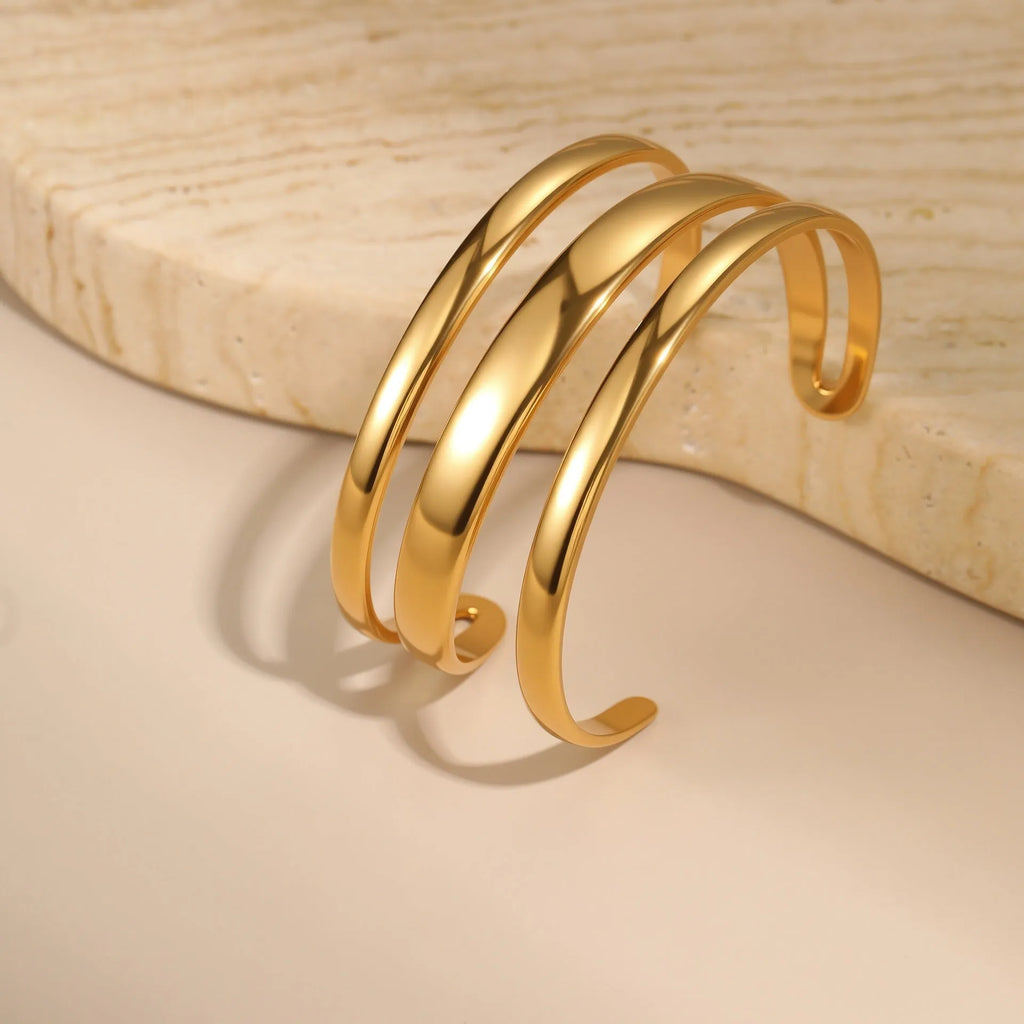 A geometric line design stainless steel bracelet with a simple opening clasp, shown in a gold electroplated finish.