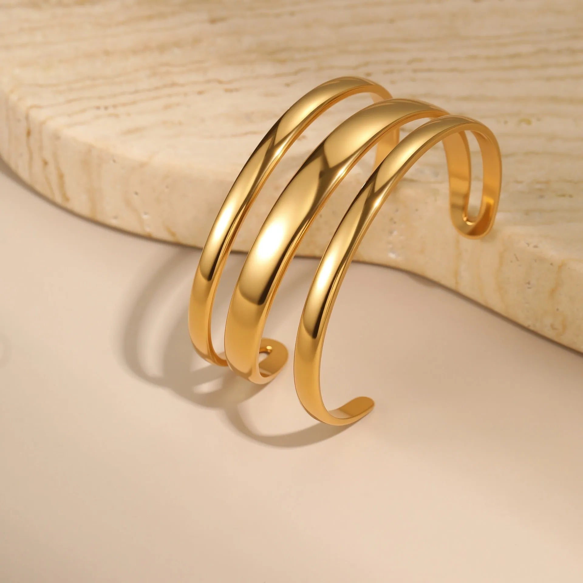 A geometric line design stainless steel bracelet with a simple opening clasp, shown in a gold electroplated finish.