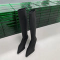 Women's black pointed toe stiletto heel boots with a back zip, shown from the side.