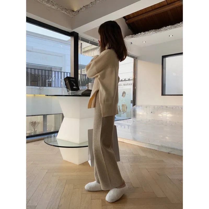 Women's cream white high waist wide-leg knitted trousers with a long mopping hem and elastic waistband.