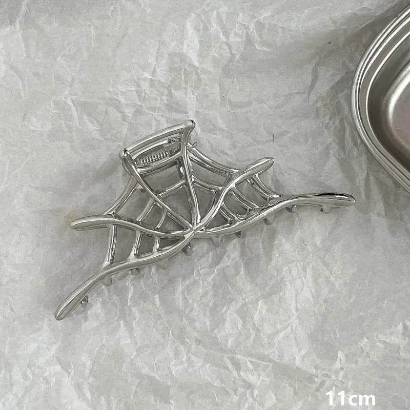 Silver metal hair claw clip assortment showing bows, waves, pearl designs, and geometric shapes from 4cm to 13.5cm