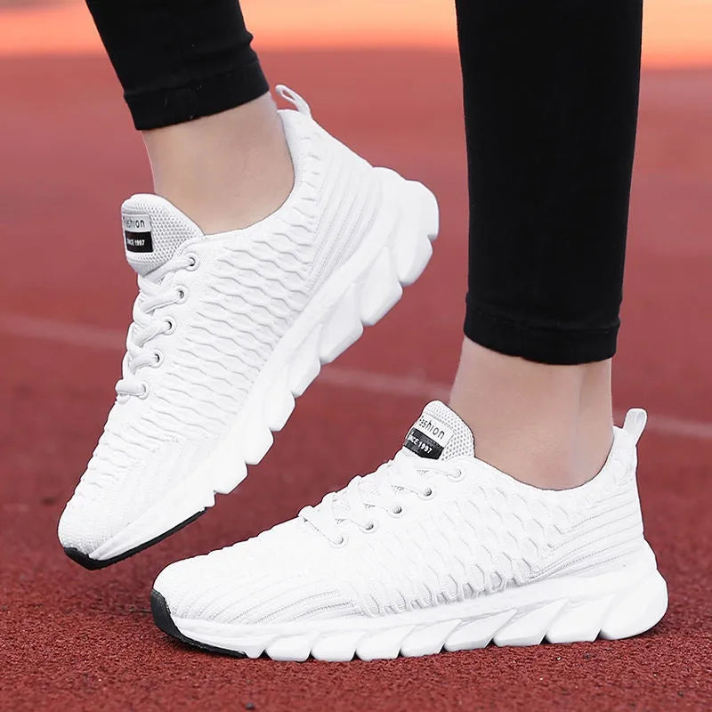 Women's running shoes in black, pink, or white with a breathable fly weave upper and wear-resistant outsole.