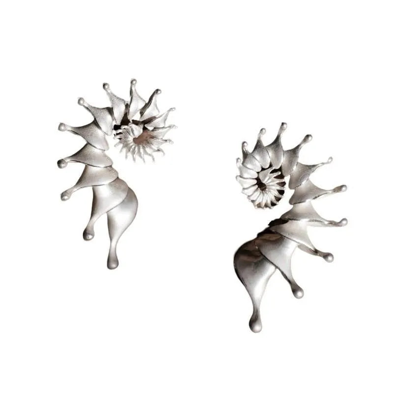Exaggerated three-dimensional conch shell stud earrings with a matte finish in an irregular abstract design.