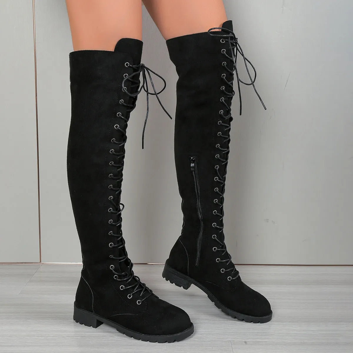 Black lace-up over-the-knee boots with flat heel, round toe and decorative stitching details