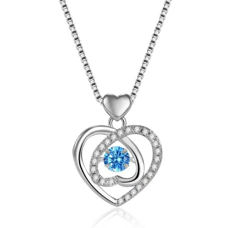 Blue diamond heart-shaped necklace and matching bracelet set with gemstone inlays on a model