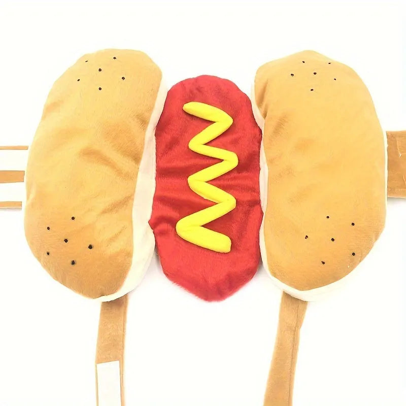 A small dog wearing a plush red and brown hot dog costume suit with mustard detailing.