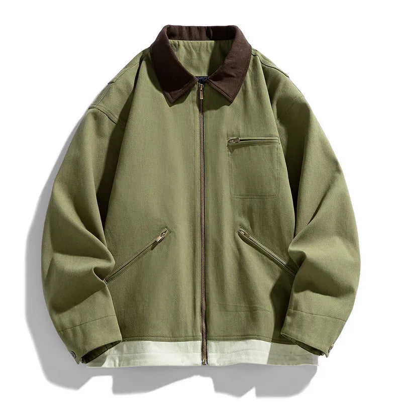 Man wearing a mint green retro-style workwear jacket with dark contrast lapels and side pockets.