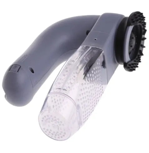 Grey handheld electric pet hair remover brush with soft rubber head, shown removing fur from upholstery.