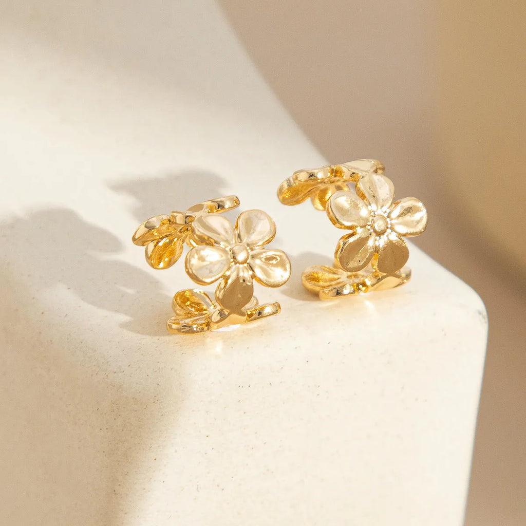 A pair of gold drop earrings featuring starfish and conch designs on an alloy base.