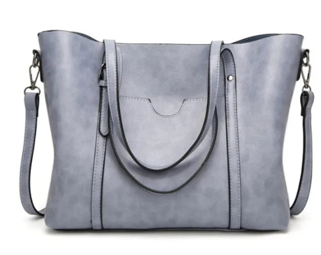 Retro-style brown PU messenger bag for women shown with shoulder strap, displaying its large main compartment.