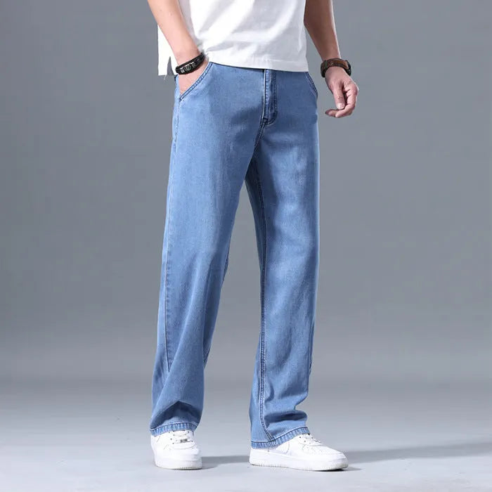 Men's loose fit straight leg lyocell jeans in light blue on a neutral background.