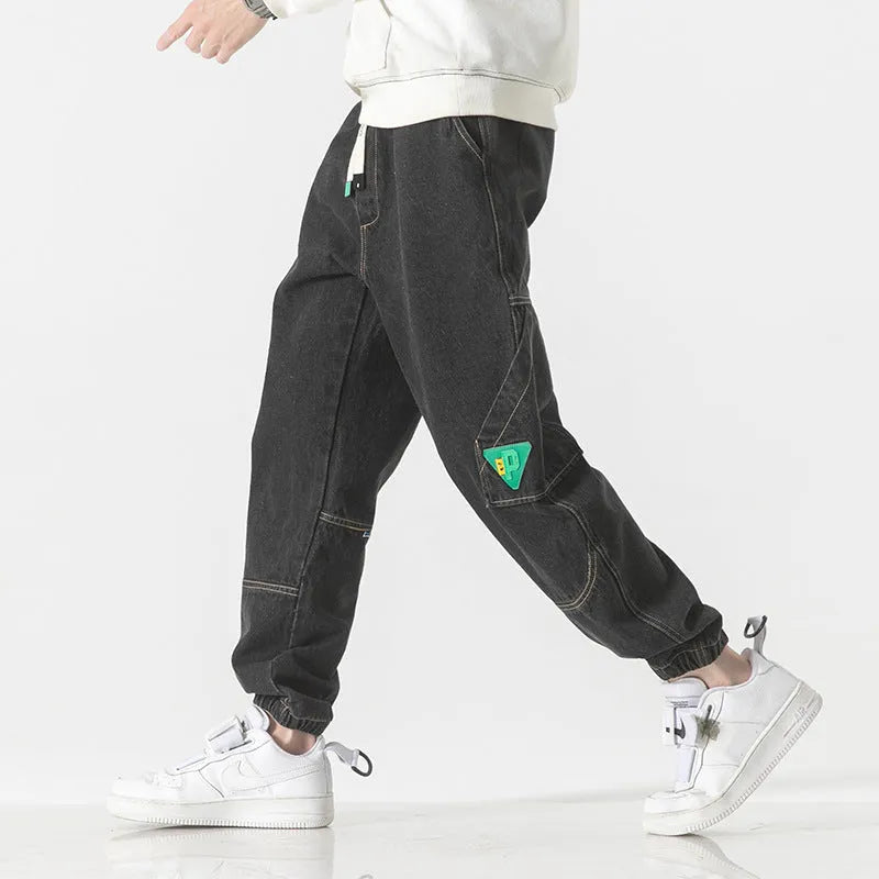 Men's loose-fit tapered cotton trousers in black, shown in a casual setting.