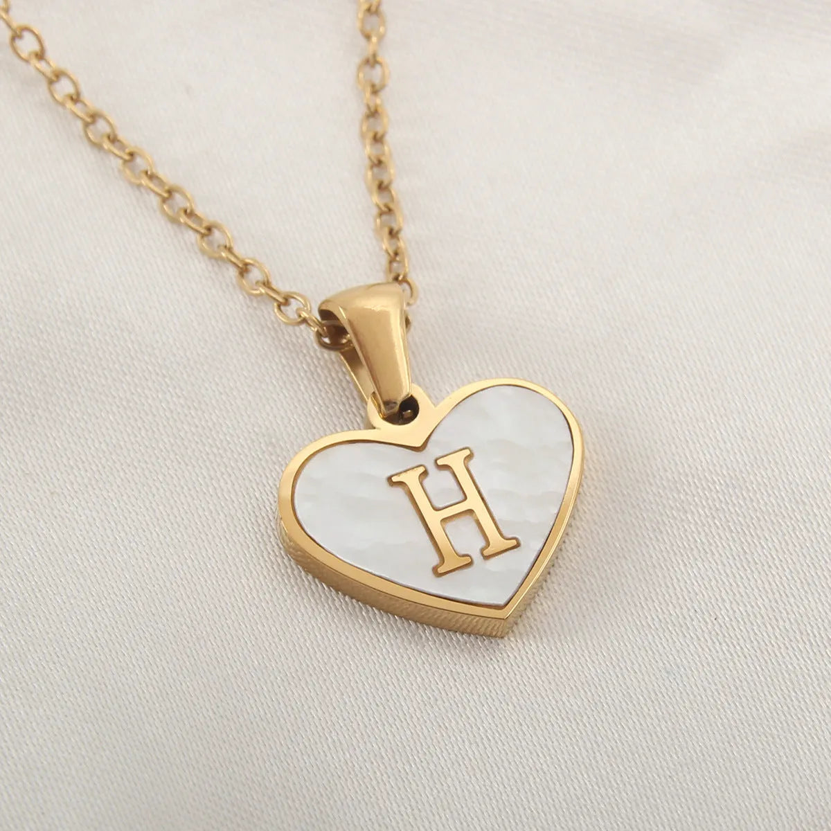 Gold plated heart-shaped necklace with white shell pendant on adjustable stainless steel chain