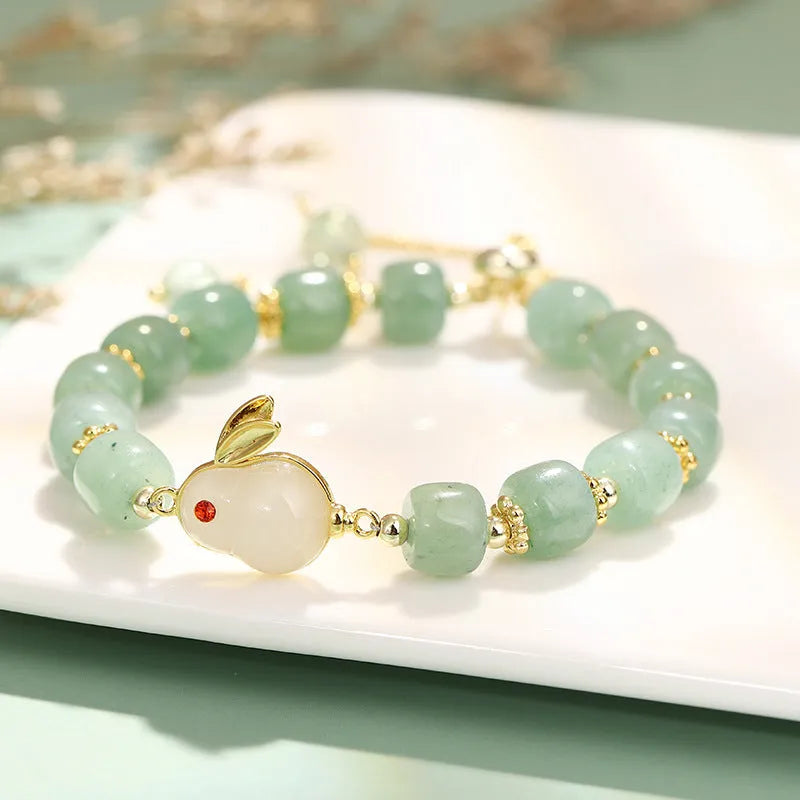 Rabbit charm bracelet with green aventurine or strawberry quartz beads on a gold-coloured adjustable chain.