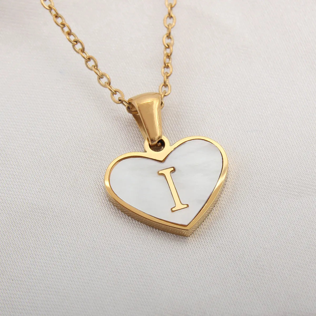 Gold plated heart-shaped necklace with white shell pendant on adjustable stainless steel chain