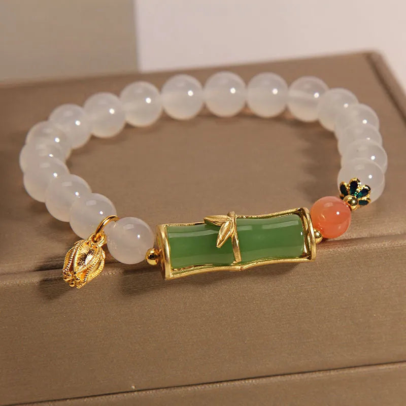 Close-up of a white agate jasper beaded bracelet with a jade bead in a Chinese bamboo style.