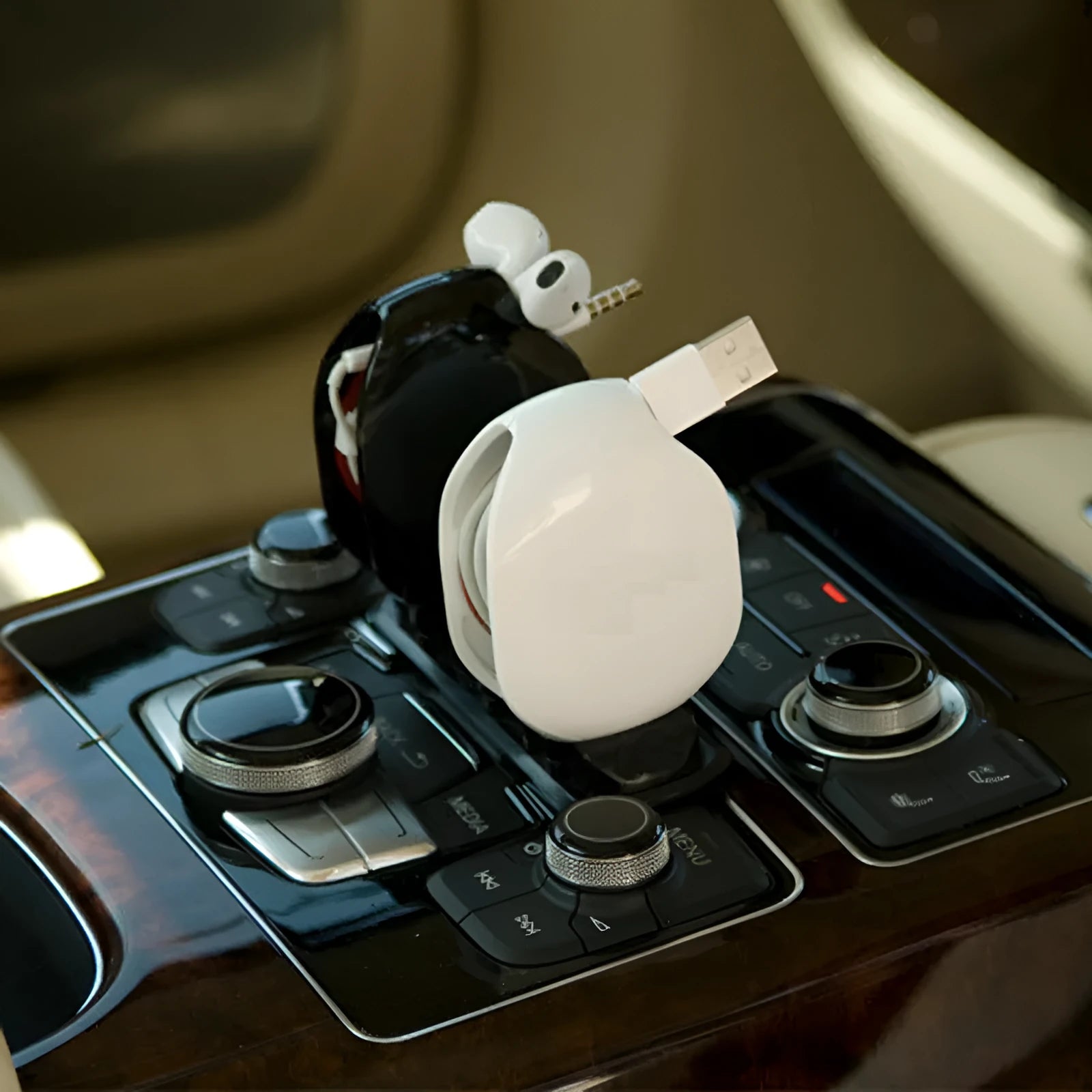 Automatic earphone retractor winder in black with extended cable showing push-type mechanism