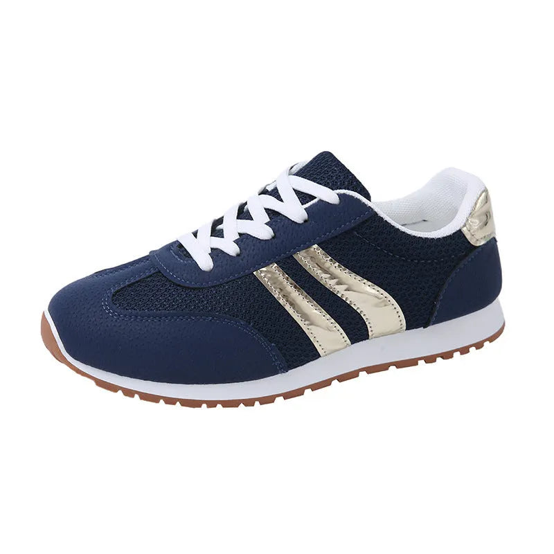 Blue women's casual tennis shoes with cross shoulder straps and white rubber sole on a flat heel.