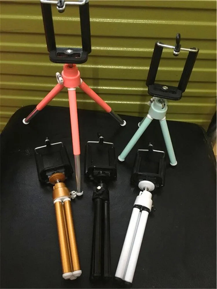 Black aluminium desktop phone holder with adjustable two-section bracket holding a mobile phone
