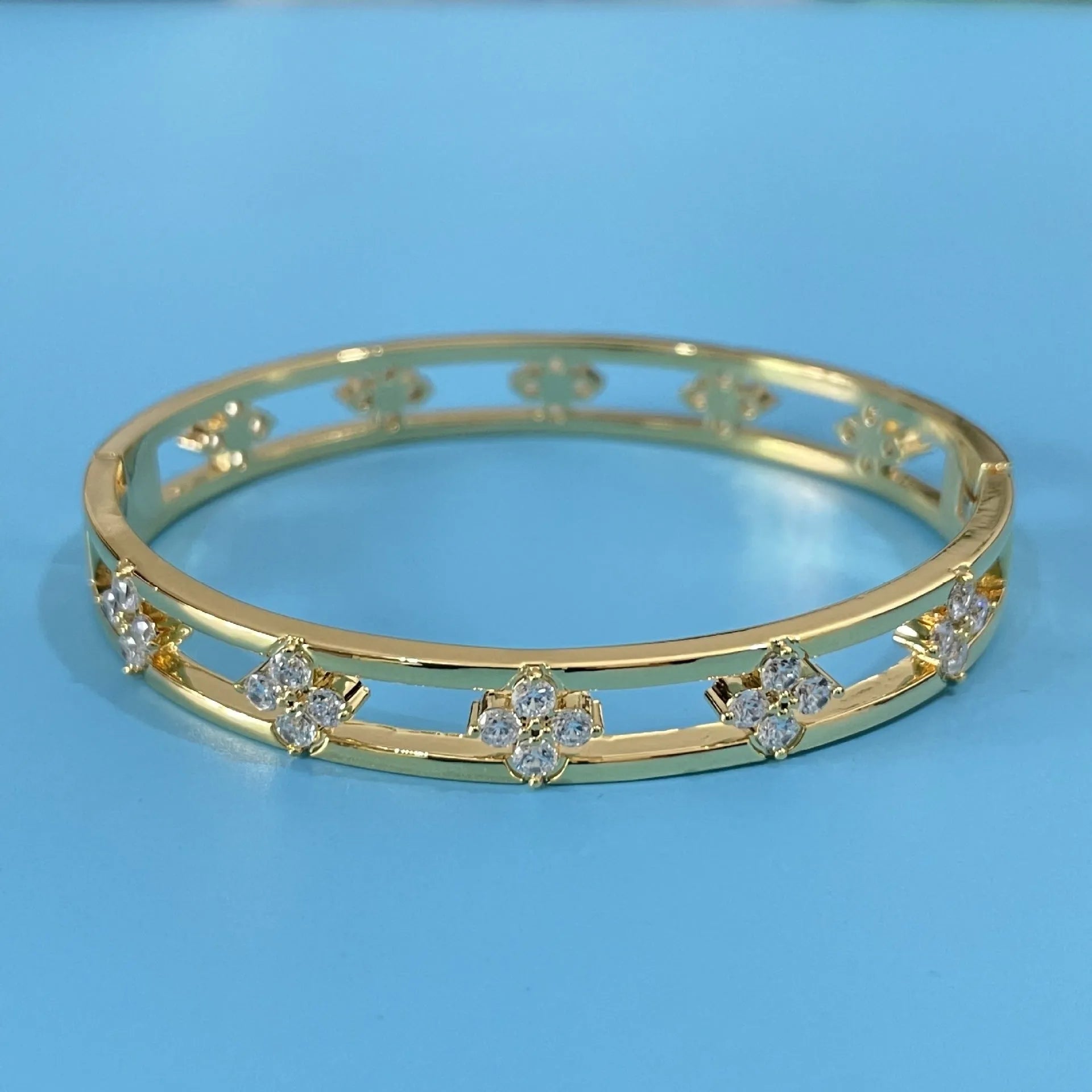 Women's hollow bracelet with four-leaf clover charm and zircon stones in gold or silver