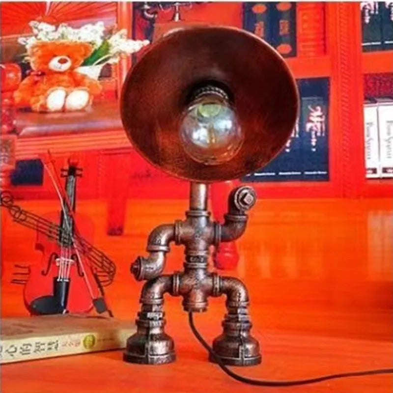 Iron pipe industrial retro style table lamp in vintage colour on a wooden desk.