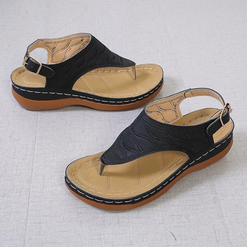 Women's wedge heel flip flop sandals with an adjustable buckle back strap in black.