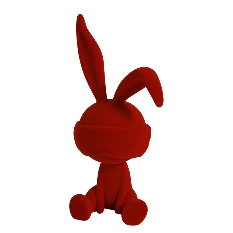 Green suede blindfold rabbit resin table ornament on wooden surface