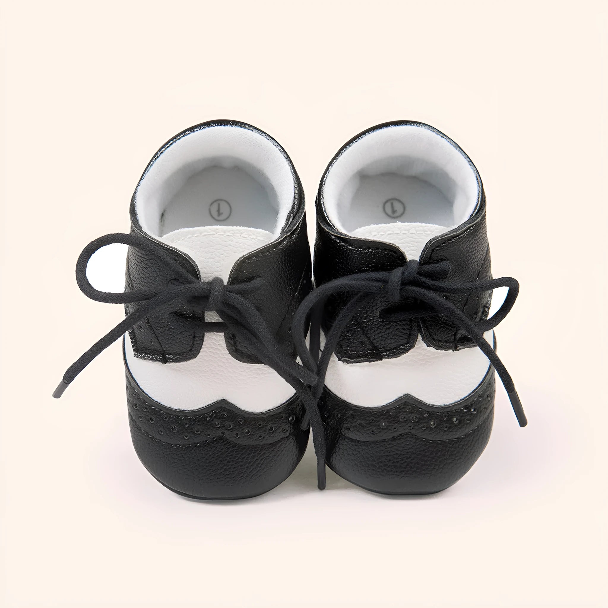 Vintage baby shoes with soft soles in light brown colour showing synthetic leather upper