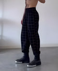 Men's plaid trousers with apron-style design in multiple sizes featuring adjustable waistband and front pockets