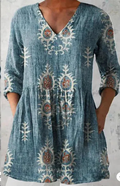 A woman wearing a printed, loose-fitting dress with a wide waist and three-quarter length sleeves.