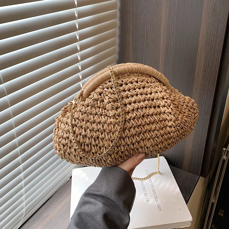 Beige shell-shaped straw shoulder bag with chain strap and woven texture.
