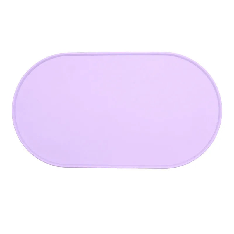 Silicone waterproof cat feeding placemat in beige colour on a wooden floor next to a pet bowl.