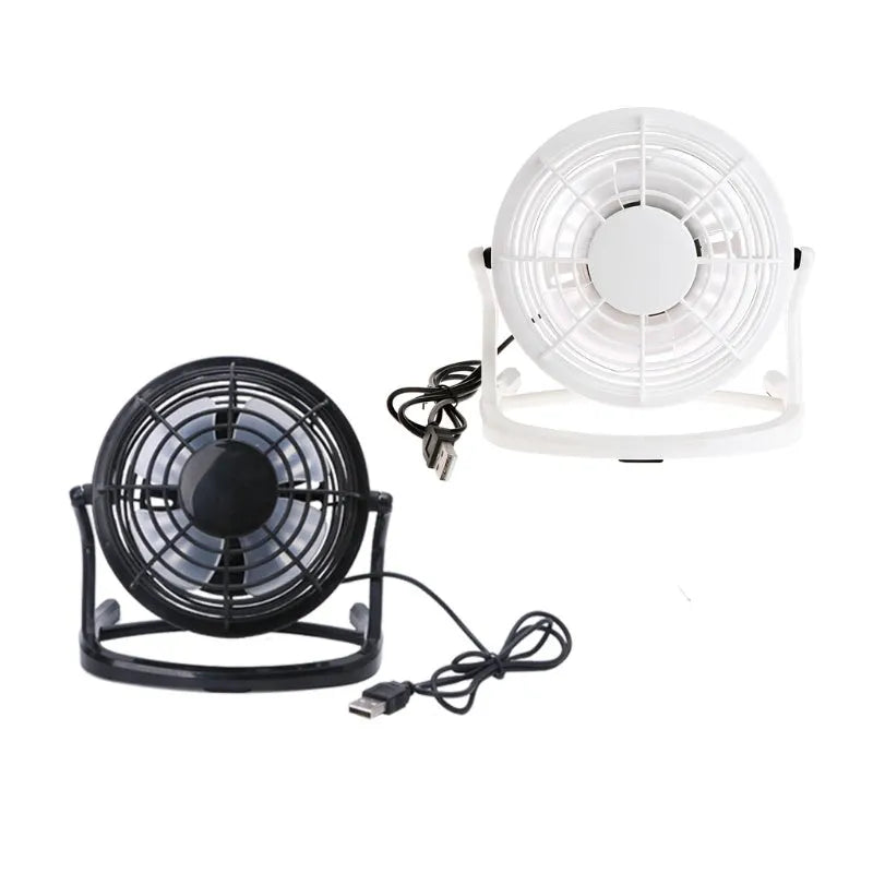 Black mini USB desk fan with adjustable head on a wooden desk next to a laptop.
