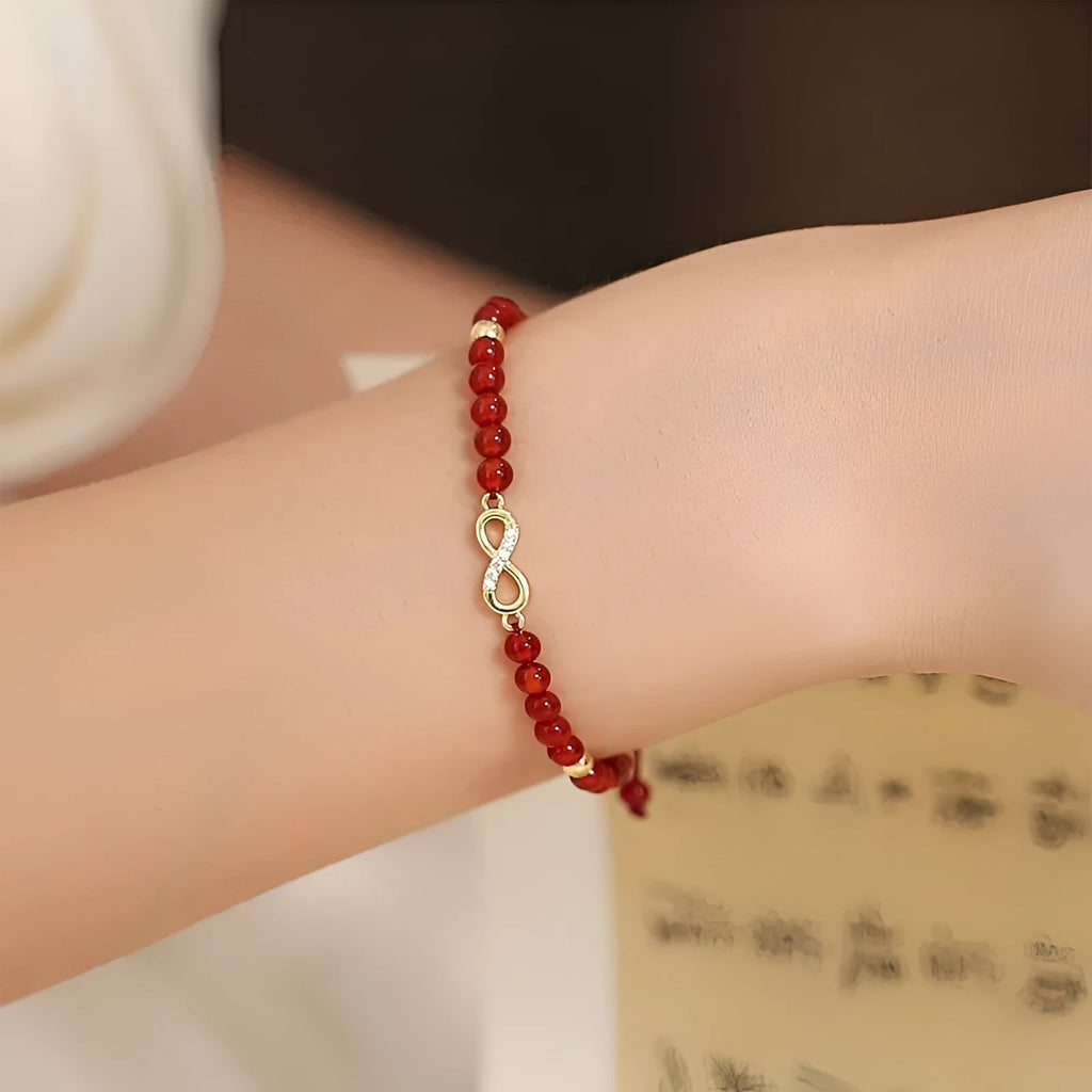 Hand-woven red agate bead bracelet with ethnic design on a wrist.