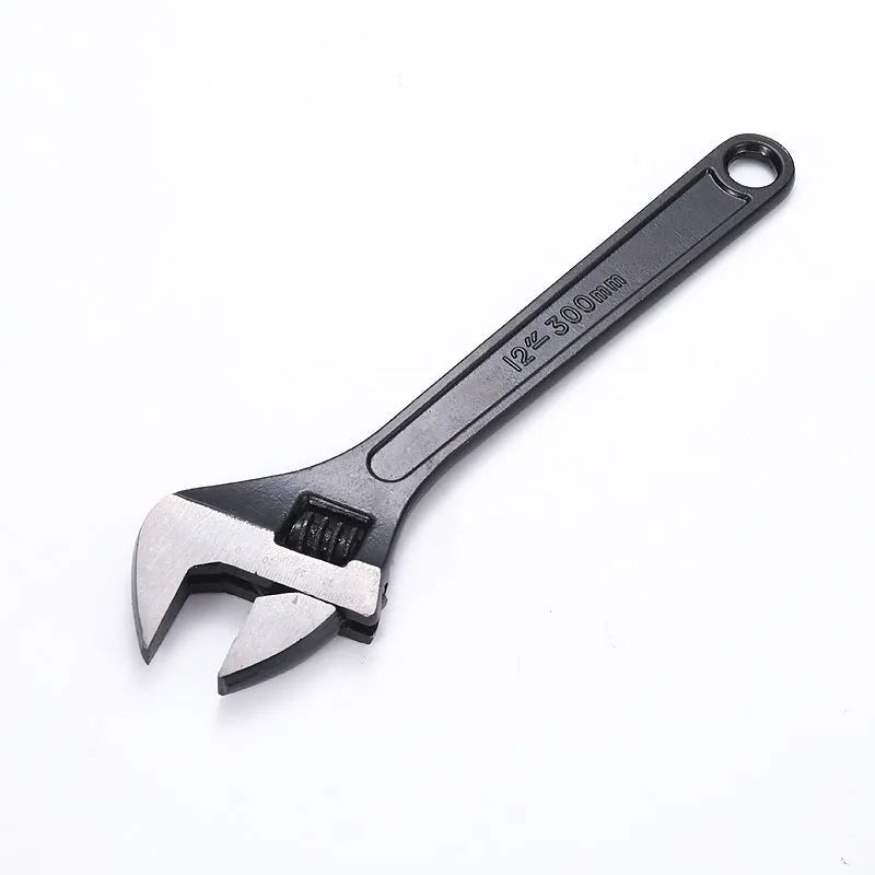Black stainless steel adjustable open-end wrench on a workbench, showing size markings and ergonomic handle.