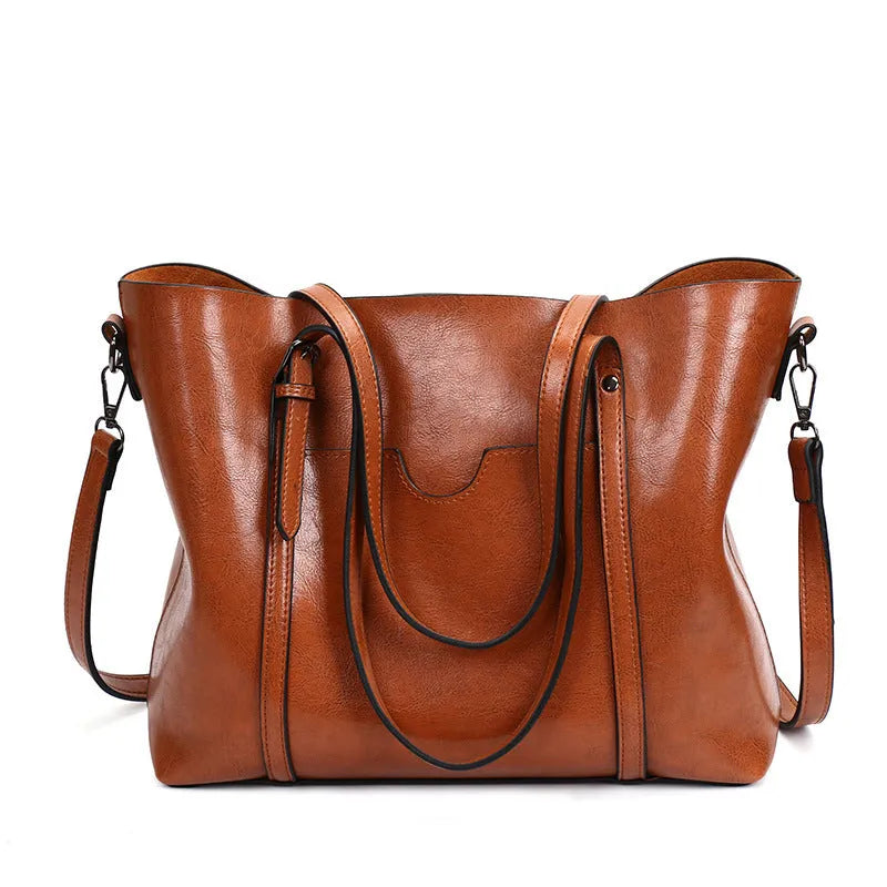 Retro-style brown PU messenger bag for women shown with shoulder strap, displaying its large main compartment.