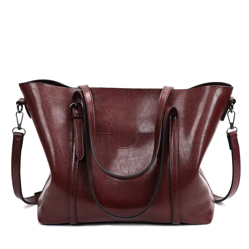 Retro-style brown PU messenger bag for women shown with shoulder strap, displaying its large main compartment.