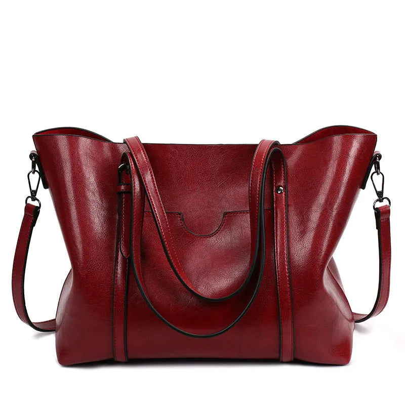Retro-style brown PU messenger bag for women shown with shoulder strap, displaying its large main compartment.