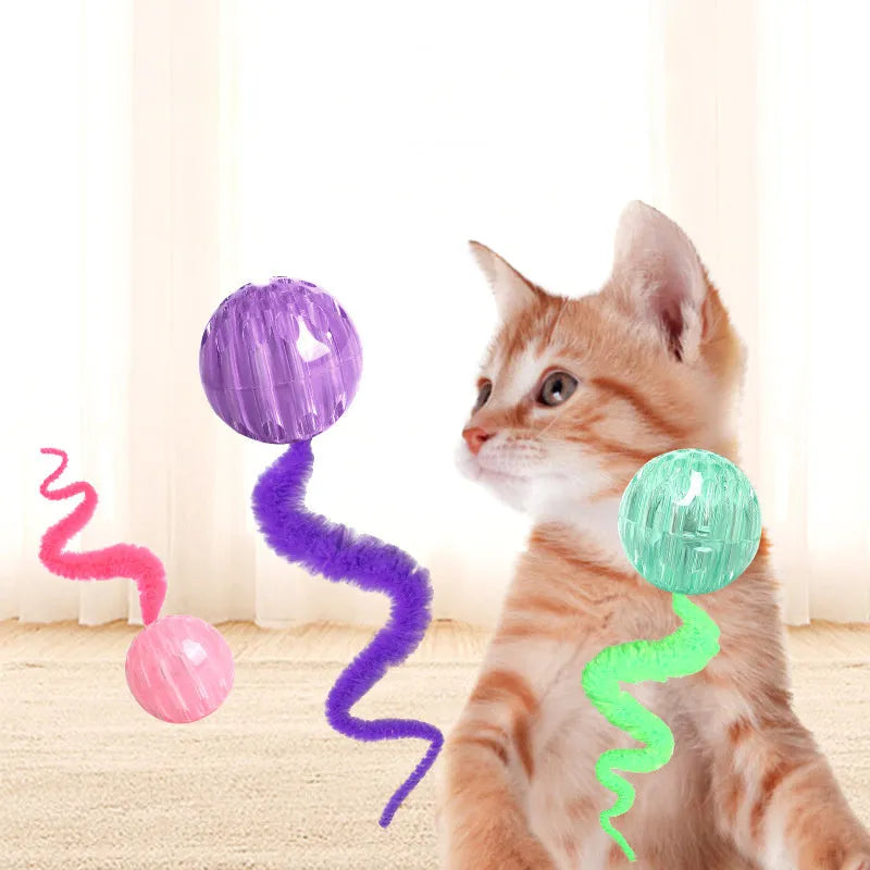 Green interactive cat toy featuring a bouncy ball with a long plush tail on a wooden floor.