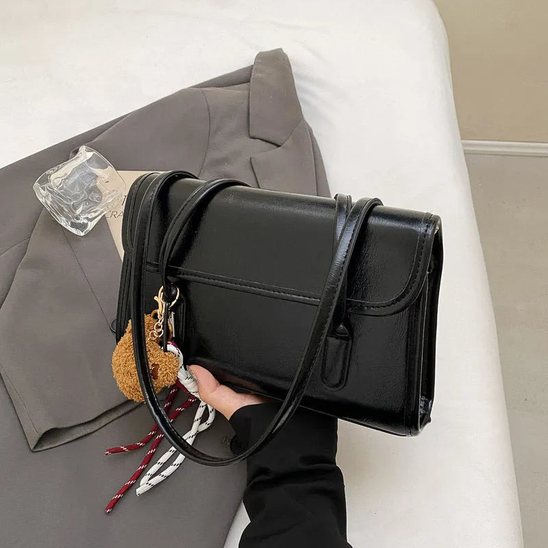 Women's brown PU leather shoulder bag with square shape, double straps, and decorative pendant attachment