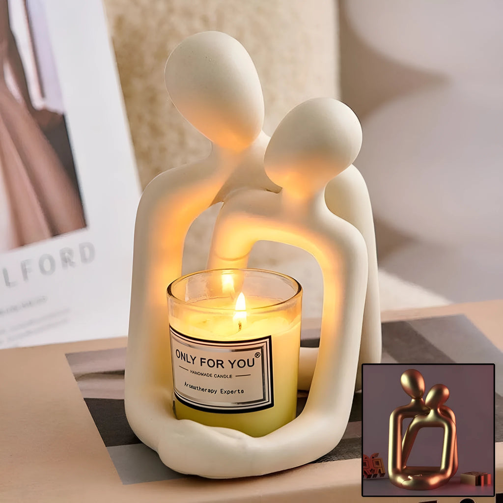 Modern resin statue of an embracing couple in milky white or gold finish on a wooden surface.