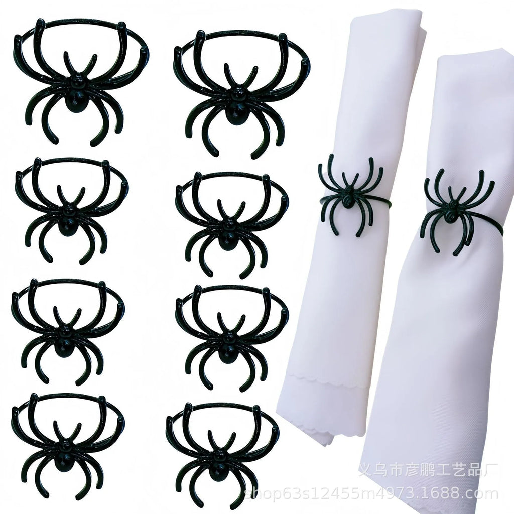 Set of six black alloy napkin rings with spider design for Halloween table decoration.
