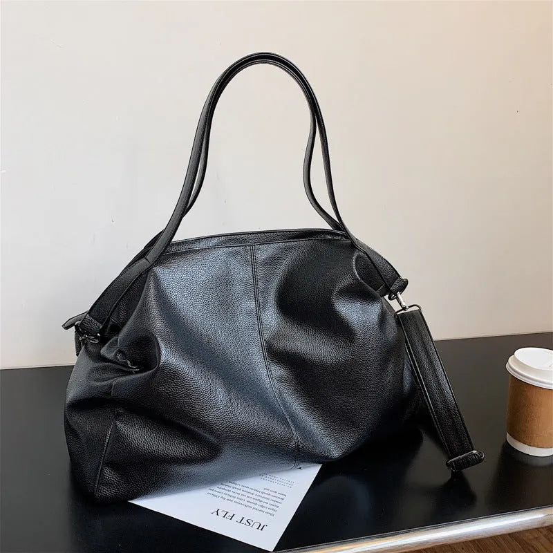 Large soft surface black messenger bag with a shoulder strap and zipper opening.