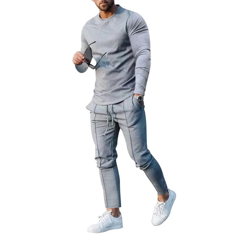 Men's light grey polyester two-piece suit with long sleeve round neck T-shirt and matching trousers laid flat.