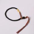 Hand-woven obsidian carrying strap bracelet showing textured weave and adjustable length