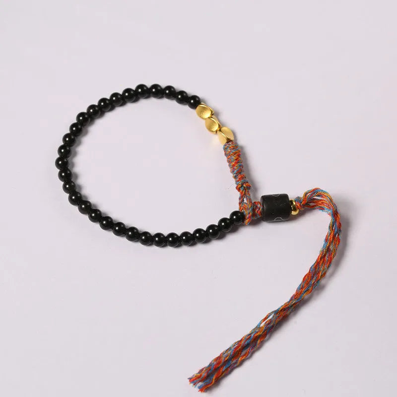 Hand-woven obsidian carrying strap bracelet showing textured weave and adjustable length