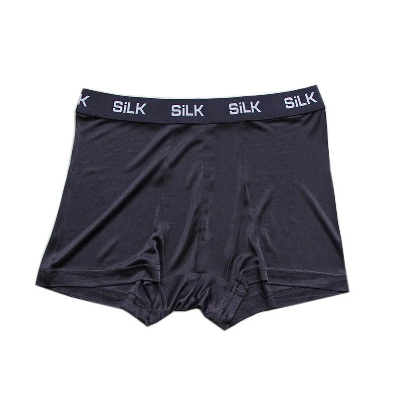 Man wearing loose fit navy blue silk shorts with a mid waist design.