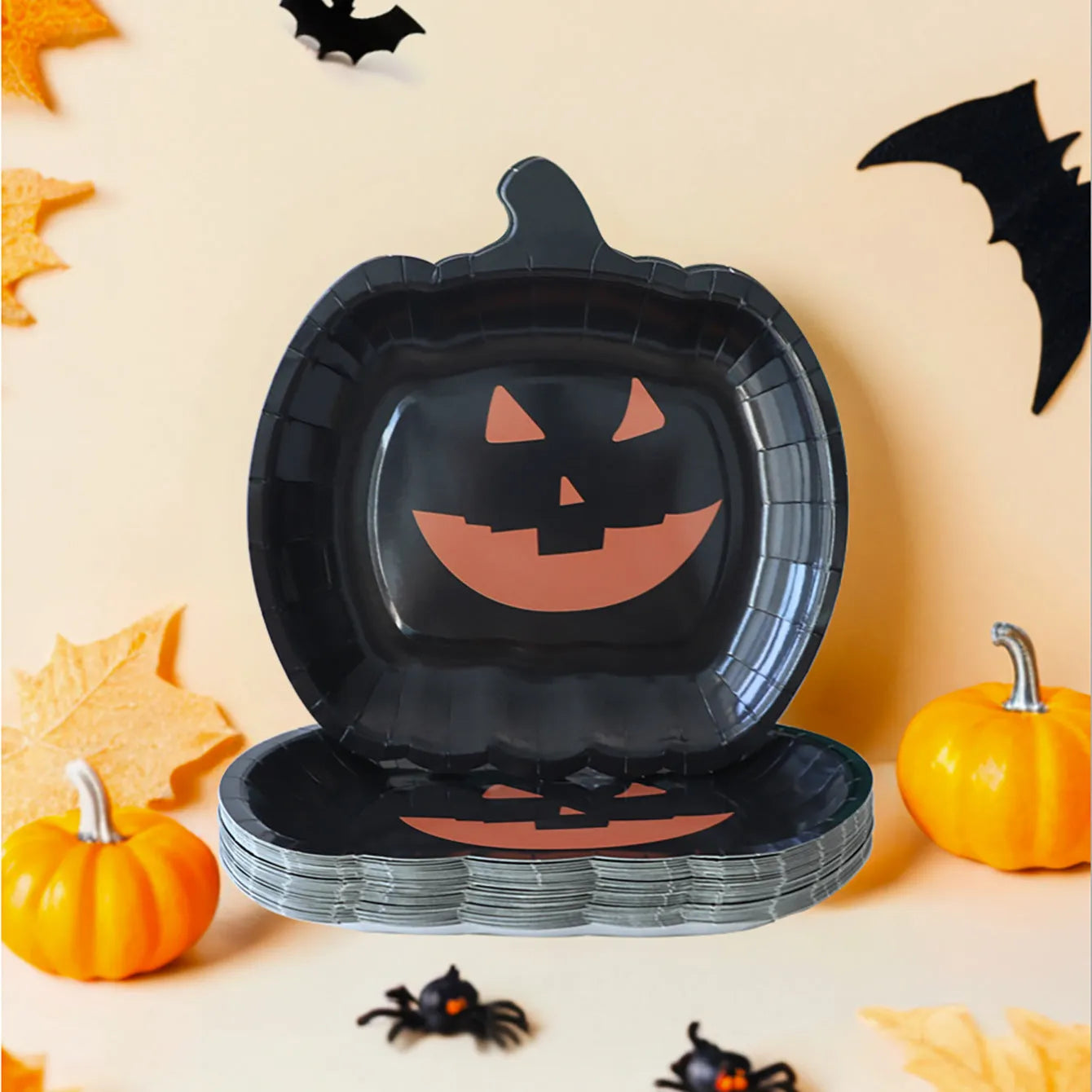 Set of black disposable Halloween paper plates with orange pumpkin design, 9 inches in diameter.