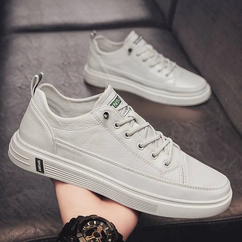 Men's white casual shoes with round toe and flat low heel on a plain background
